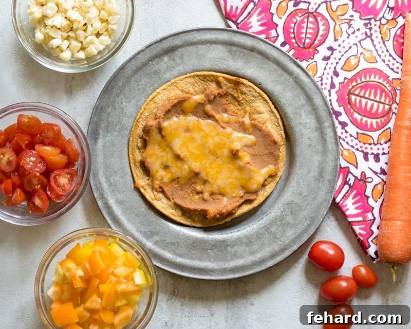 Baked Tostadas with Fresh Toppings Two freshly baked tostadas on a plate, garnished with vibrant toppings like charred corn, diced tomatoes, and creamy avocado, with extra toppings in small bowls nearby.