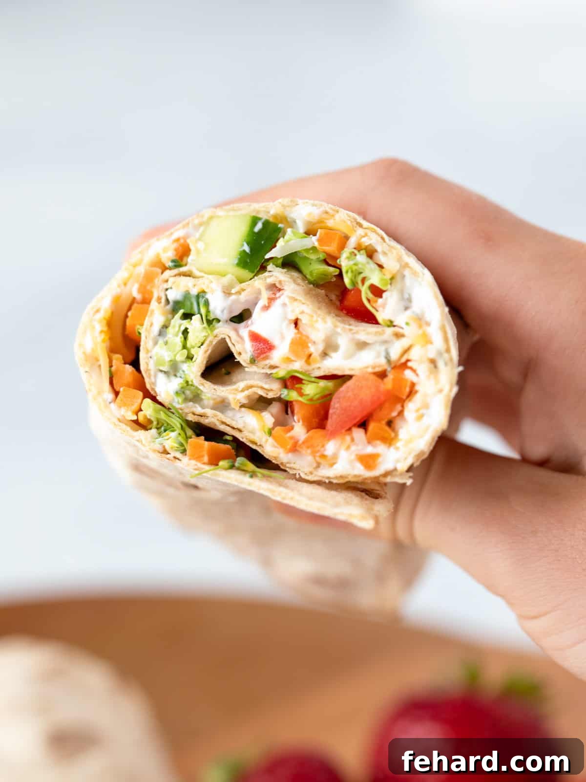 Ultimate Veggie Wrap Veggie Wrap cut open showing a vibrant medley of vegetables and creamy ranch sauce.