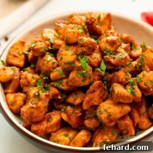 Caramelized chicken bites served in a large bowl, garnished with fresh parsley.