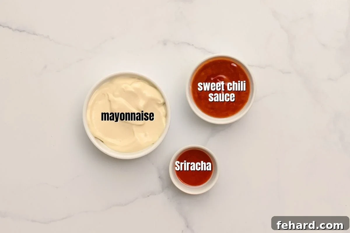 Mayonnaise, sriracha, and sweet chili sauce portioned out in small bowls labeled on counter for bang bang sauce preparation.