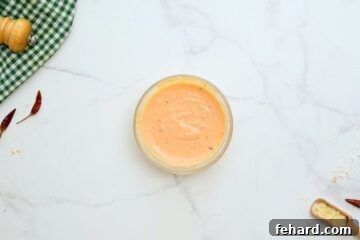The three core ingredients for Bang Bang Sauce – mayonnaise, Thai sweet chili sauce, and Sriracha – perfectly blended together in a small mixing bowl, ready to be chilled.