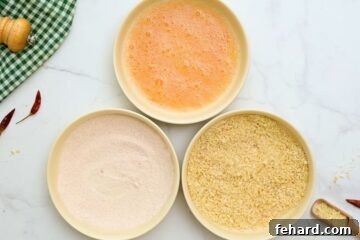 Three shallow dishes with seasoned flour, Sriracha-infused egg wash, and seasoned panko breadcrumbs, forming a breading station for Bang Bang Shrimp.