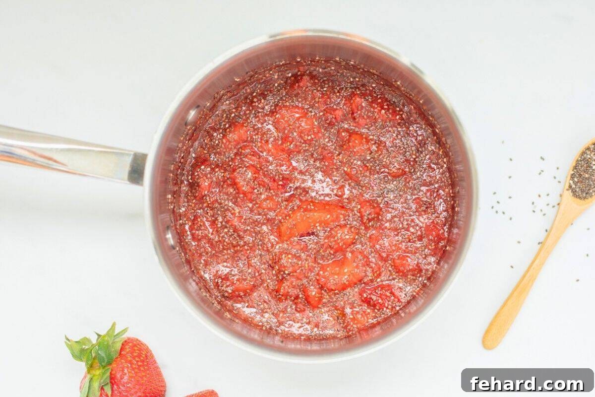 Chia seeds and lemon juice stirred into saucepan with simmered strawberries.