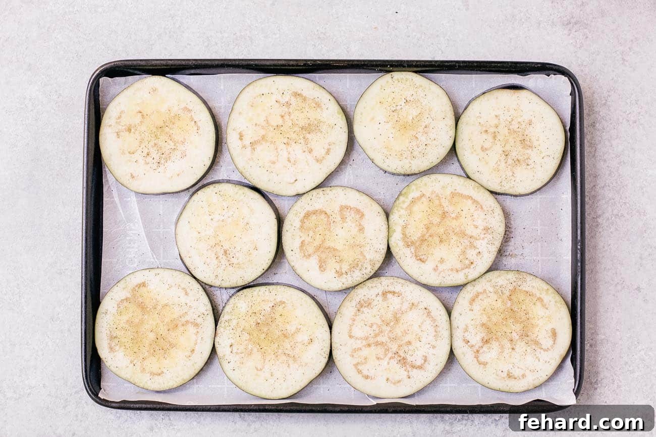 Mini Eggplant Pizzas 3 raw slices of eggplants on a baking sheet