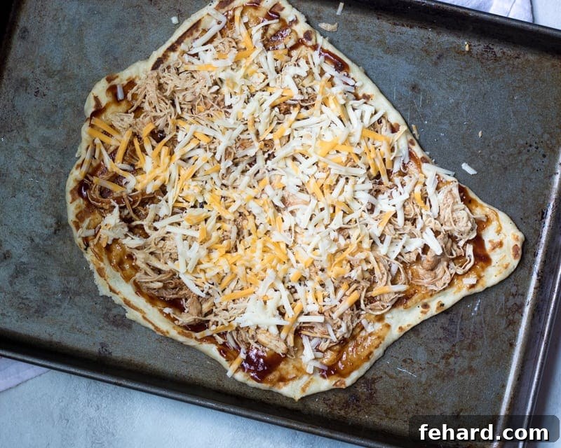 Grilled pizza dough topped with a generous layer of seasoned pulled pork.