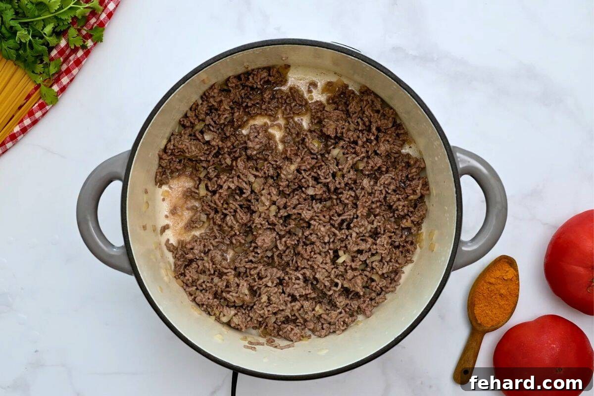 Tex Mex Spaghetti Recipe Ground beef and onion sauteed together in large stock pan for Tex Mex Spaghetti.