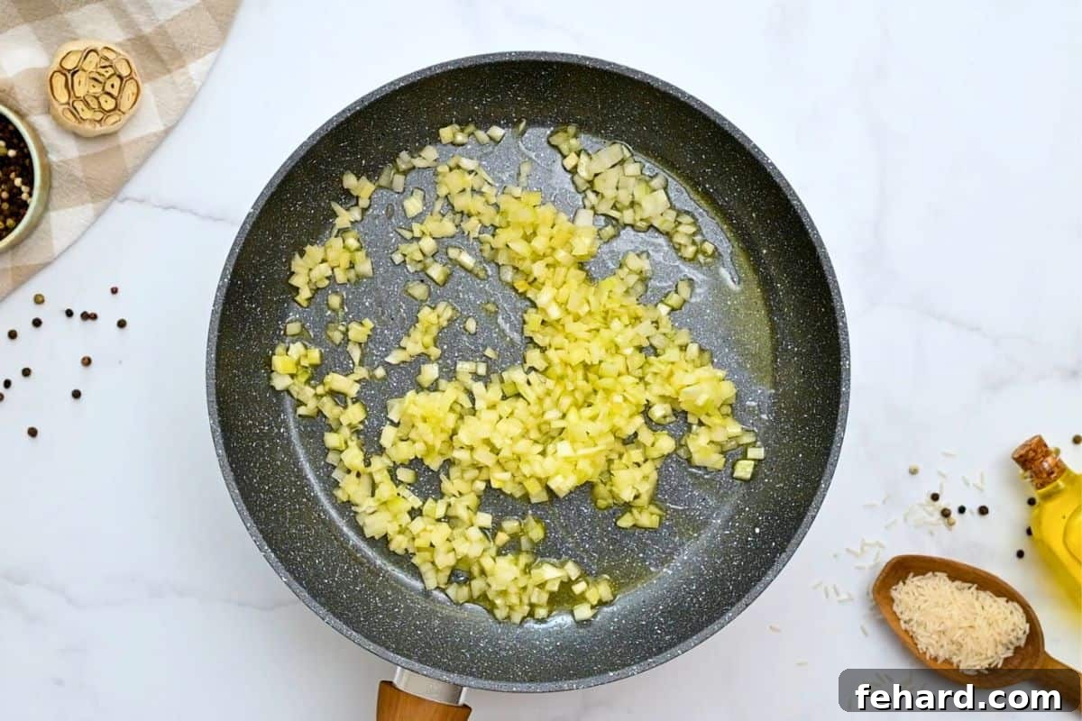 Minced onion and garlic sauteed in skillet in butter and olive oil with orzo and rice to the side.