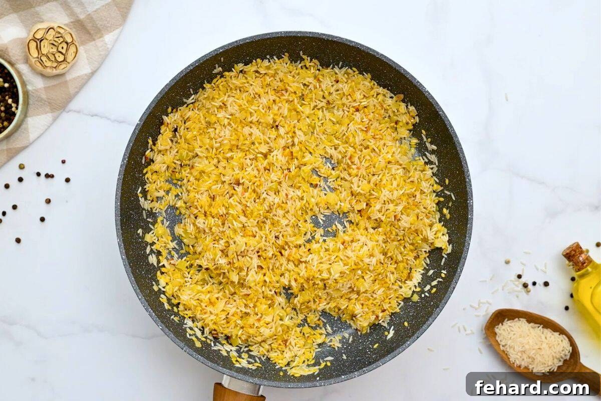 Orzo and rice toasted in skillet with onion and garlic.