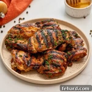 Honey soy marinated chicken thighs on platter topped with minced parsley, showcasing delicious results.