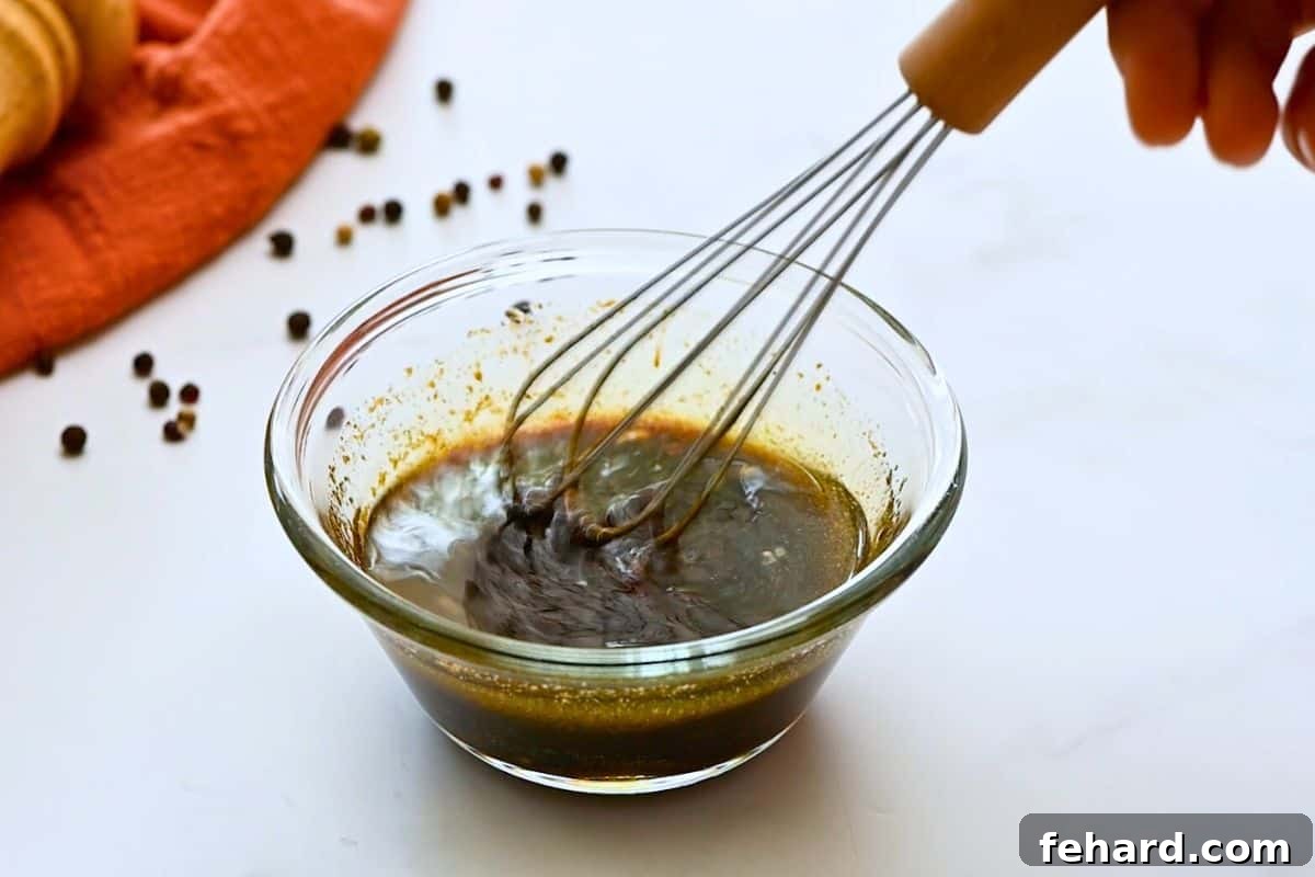 Small dish with soy, honey, olive oil, garlic, onion powder, salt, and pepper whisked together, ready for chicken.