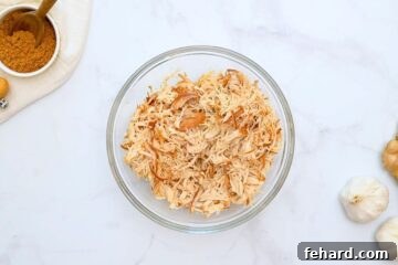 Shredded Crockpot Chicken in mixing bowl.
