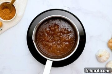 Simmering teriyaki sauce inside small saucepan.