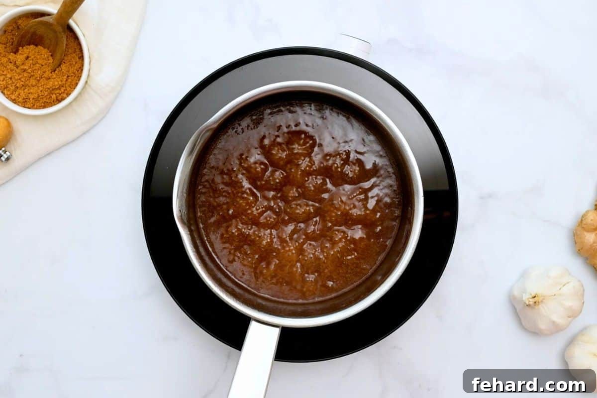 Simmering teriyaki sauce bubbling in a small saucepan, thickening to perfection.