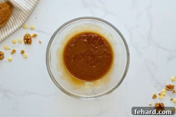 Browned butter in mixing bowl with brown sugar, vanilla, and egg whisked into the butter, creating a smooth, inviting base.