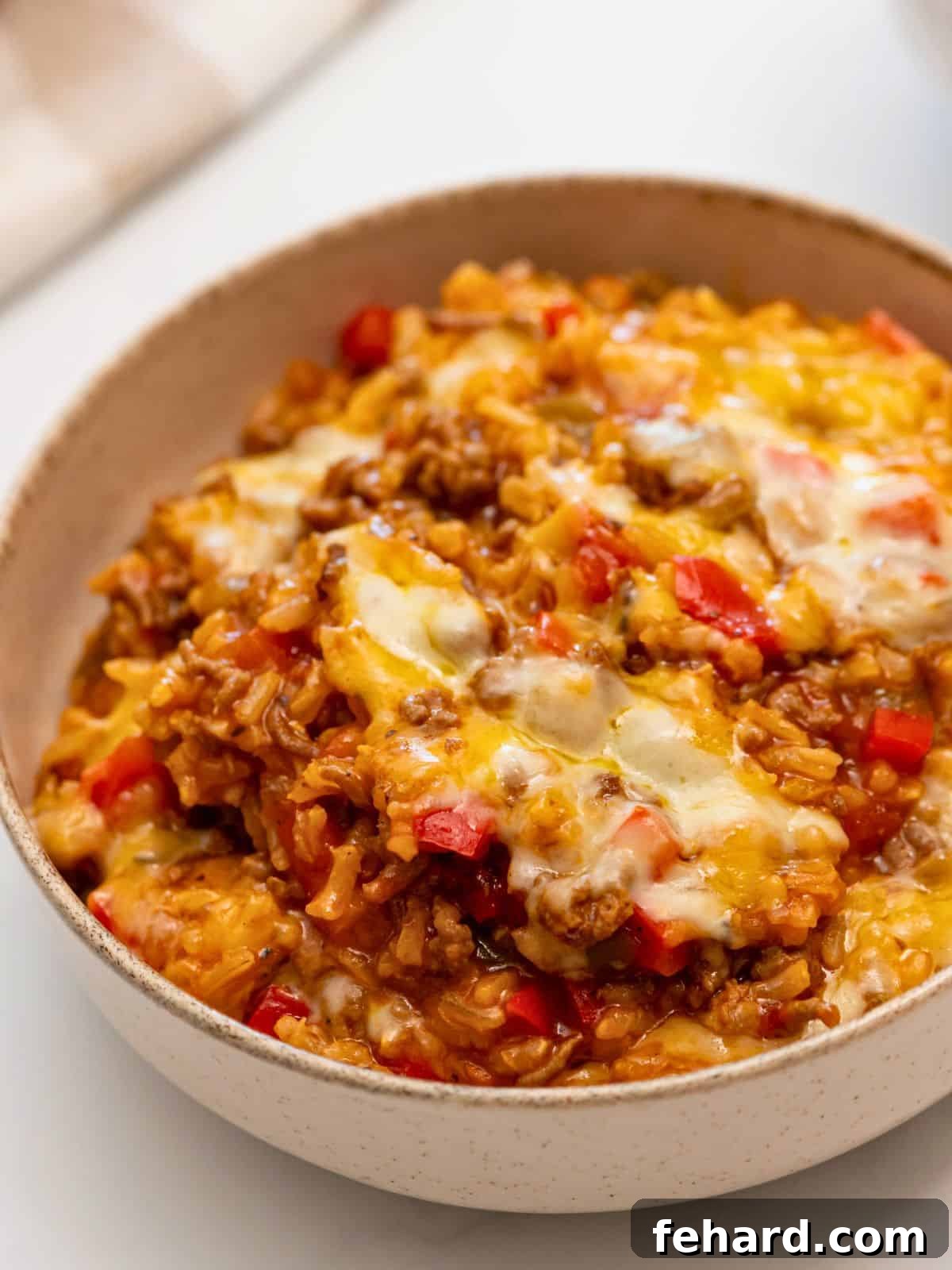 Hearty Stuffed Pepper Casserole Cheesy Stuffed Pepper Casserole served in a bowl, showcasing saucy rice, flavorful beef, and fresh bell peppers.