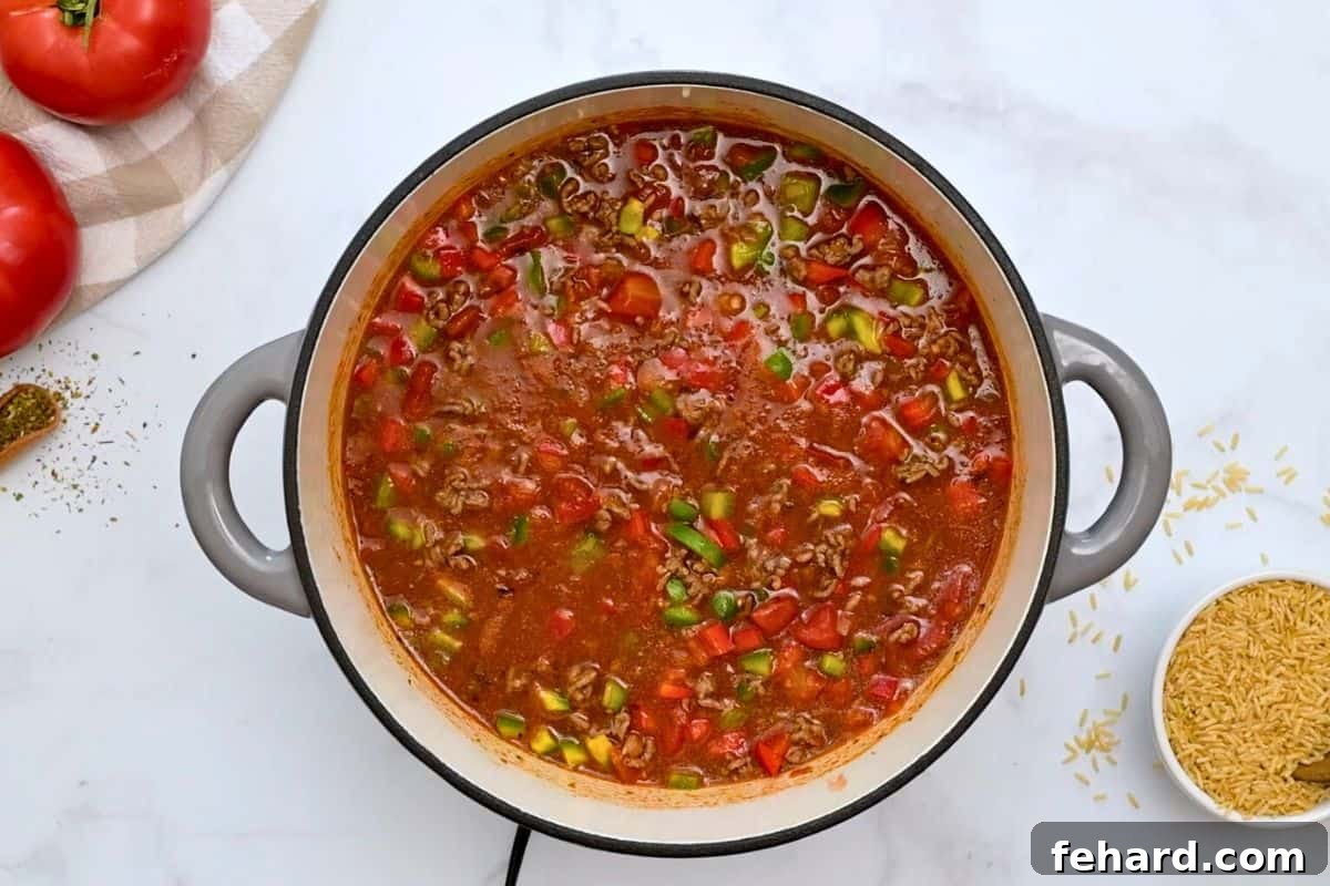 Unstuffed Pepper Casserole Simmering Ground beef, vibrant bell peppers, and brown rice simmering in a rich tomato broth within a large stockpot.