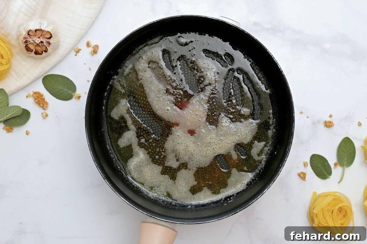 A non-stick skillet containing perfectly browned melted butter, ready for the next step of the pumpkin pasta sauce.