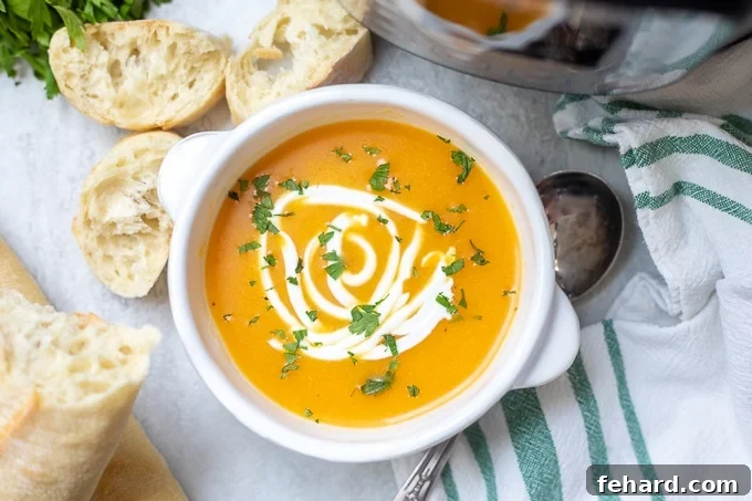 A creamy bowl of Instant Pot Butternut Squash and Apple Soup, served alongside slices of crusty bread.
