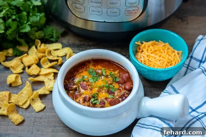 A hearty bowl of classic Instant Pot Chili, served next to the Instant Pot, ready for a comforting meal.
