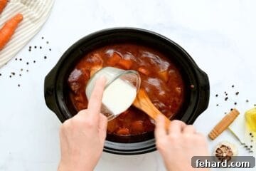 Cornstarch slurry being whisked into slow cooked beef stew.
