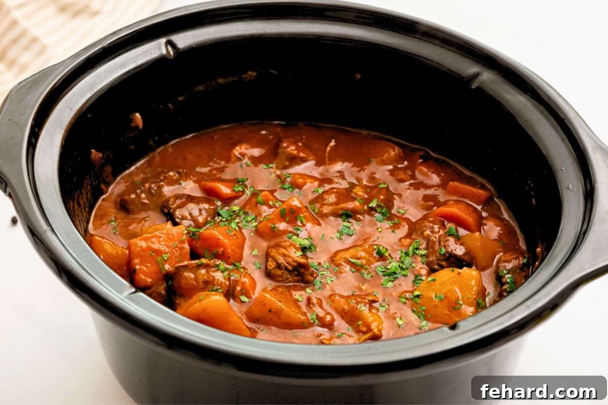 A close-up of thickened Crockpot Beef Stew, garnished with fresh parsley, showcasing its rich, velvety broth and tender ingredients.