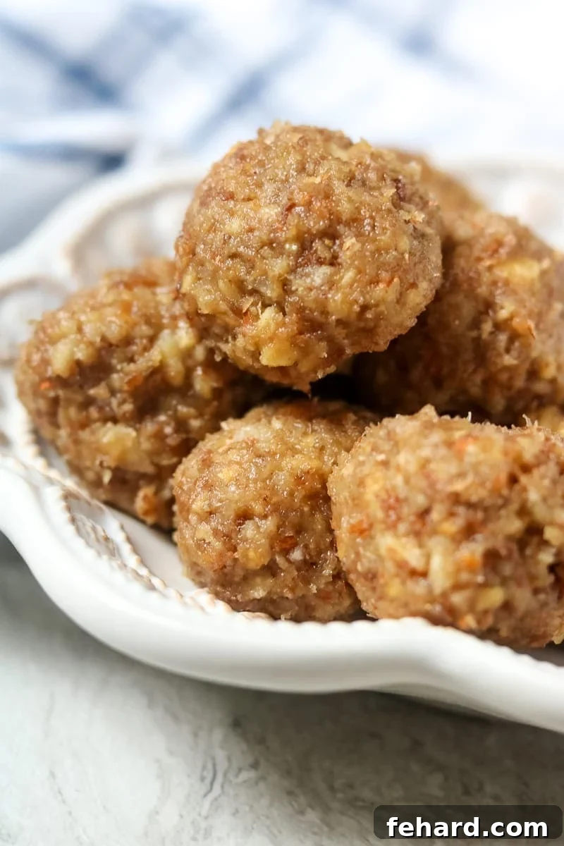 White tray of homemade Larabars shaped into bite-sized balls on parchment paper.