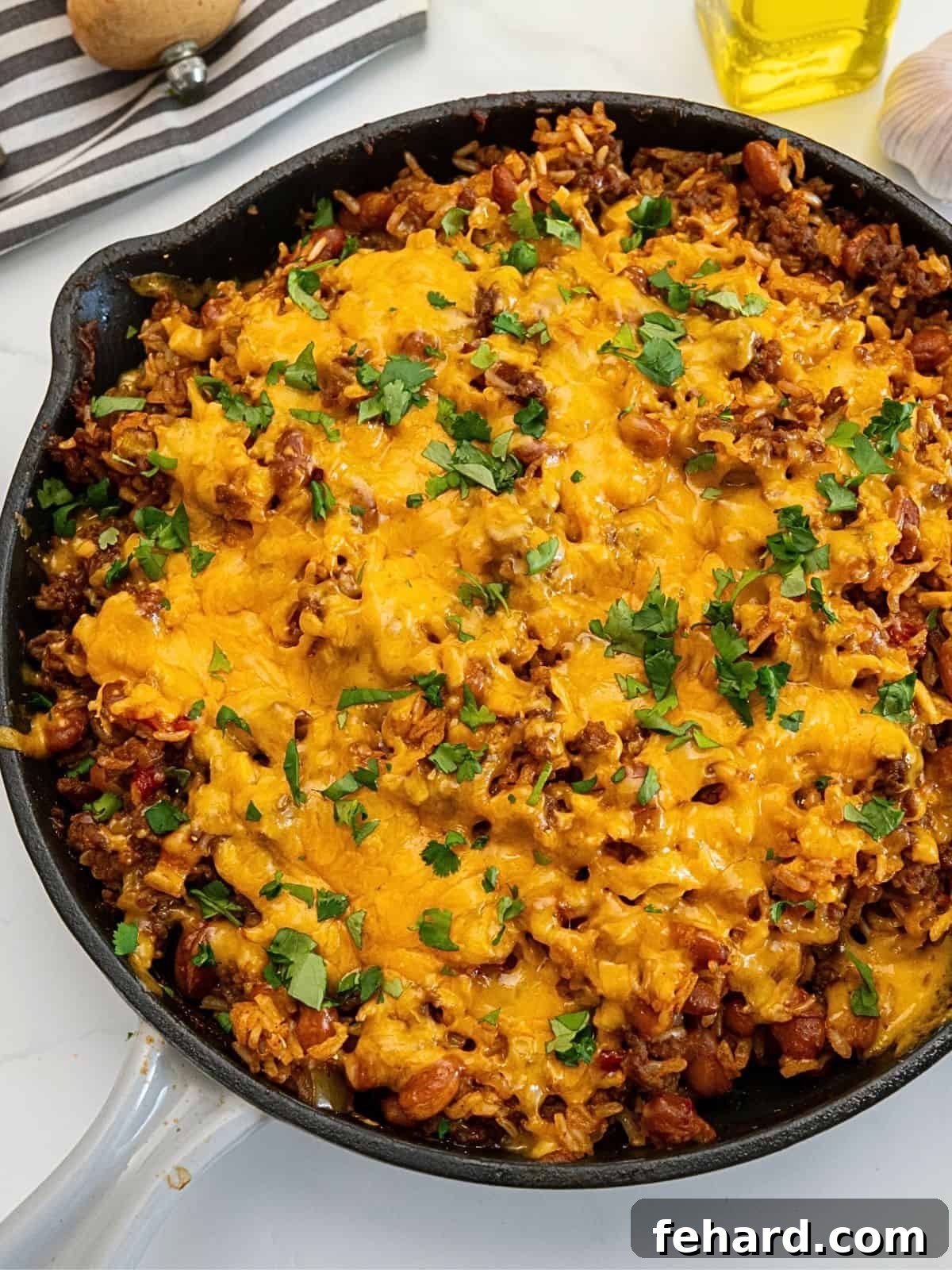 Taco Rice Casserole Deep skillet with a freshly baked Taco Rice Casserole, featuring perfectly cooked rice, savory ground beef, tender beans, and a golden layer of melted cheese.