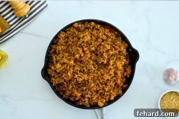 Fiesta Taco Rice Bake 6 Baked rice with taco meat and pinto beans fluffed in skillet.