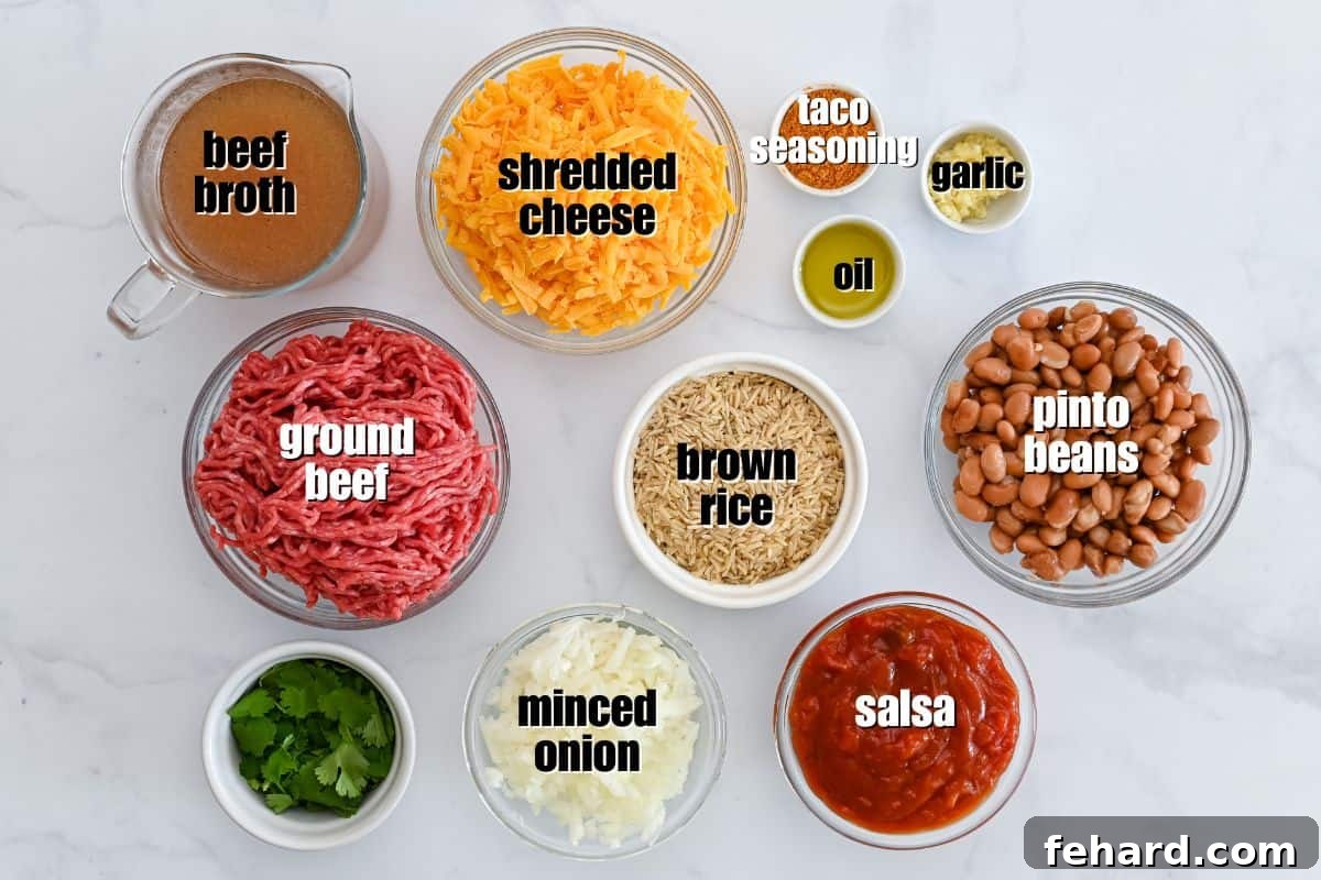 Taco Bake with Rice A collection of fresh ingredients for Taco Rice Casserole laid out on a kitchen counter, including ground beef, rice, beans, salsa, broth, onions, garlic, and cheese.