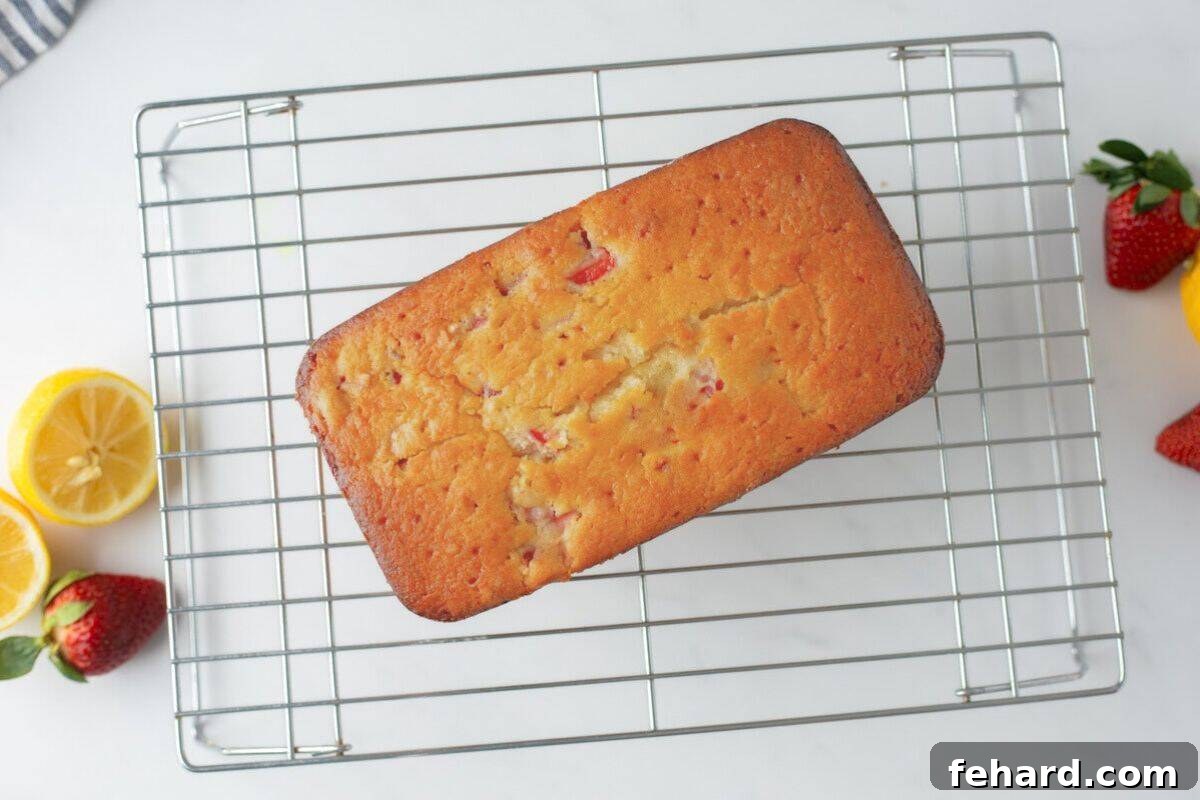 Strawberry loaf on wire rack cooling after being baked and glazed.