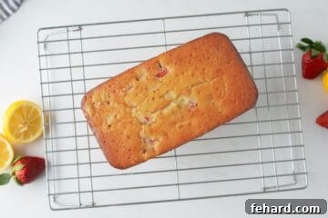 Strawberry loaf on wire rack cooling after being baked and glazed.