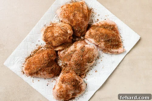 Easy Slow Cooker Chicken and Rice 10 seasoned raw chicken thighs on a countertop, ready for cooking.