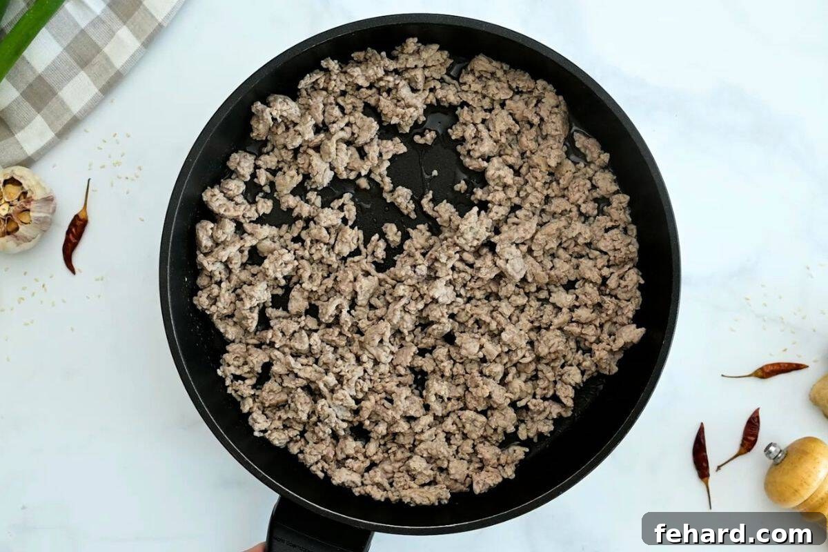 Low Carb Egg Roll in a bowl Browned ground turkey in skillet for base of egg roll bowl.