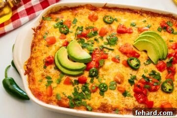 The finished beef enchilada casserole, baked to golden perfection and garnished with fresh toppings.