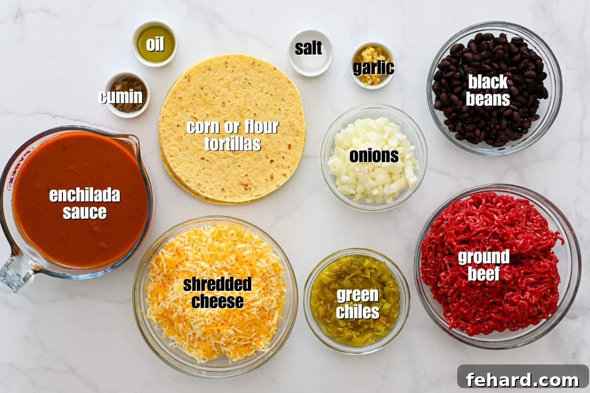 An overhead shot of the ingredients for beef enchilada casserole, including ground beef, shredded cheese, enchilada sauce, tortillas, black beans, and spices, all labeled for clarity.
