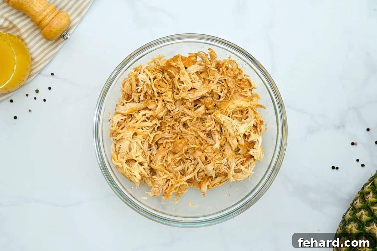 Crockpot Shredded BBQ Chicken Breasts Slow cooked chicken breasts shredded in large mixing bowl.