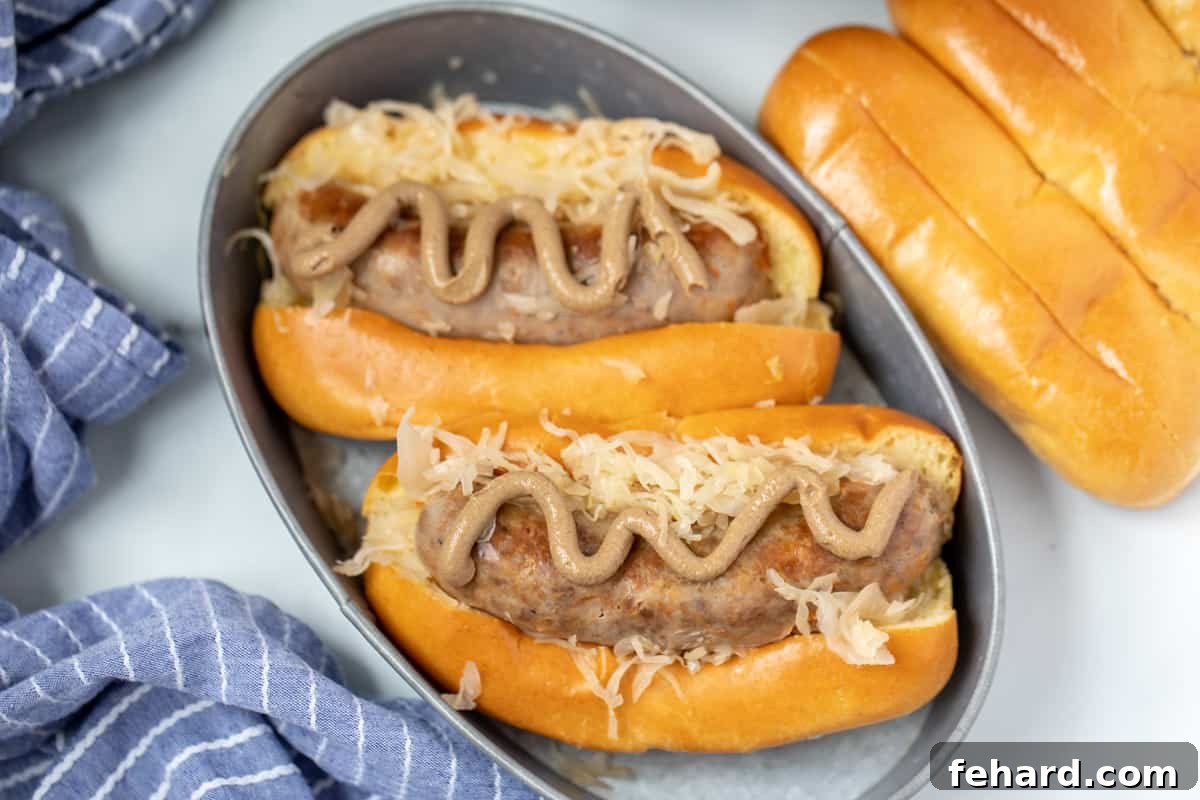 Two bratwurst in buns with sauerkraut and mustard next to instant pot.