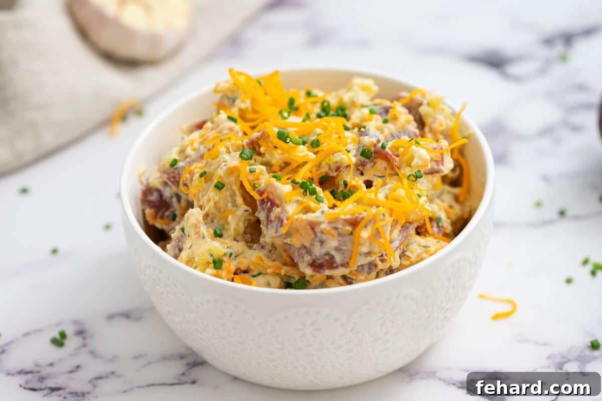 Bacon Ranch Potato Salad topped with cheese, chives, and bacon.