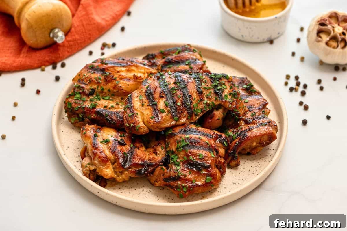 Grilled marinated chicken thighs on platter topped with minced parsley.