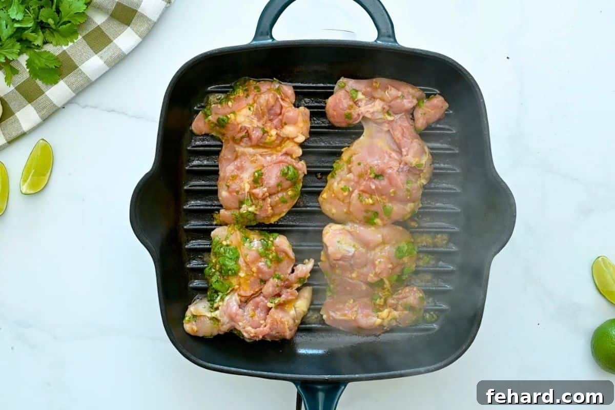 Four chicken thighs marinated in cilantro lime marinade on grill pan.