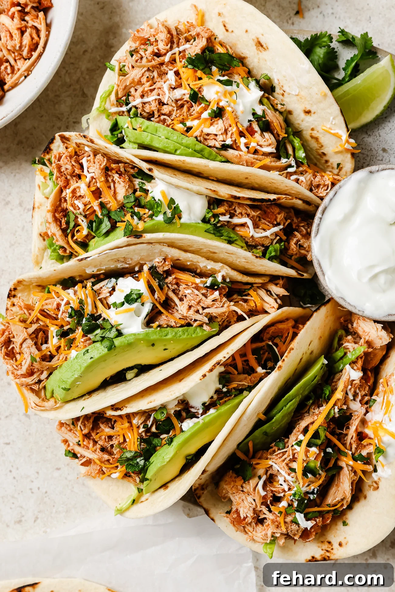 Slow Cooker Shredded Chicken Tacos with Flavorful Salsa 2 Slow Cooker Chicken Tacos with fresh toppings on a kitchen countertop.