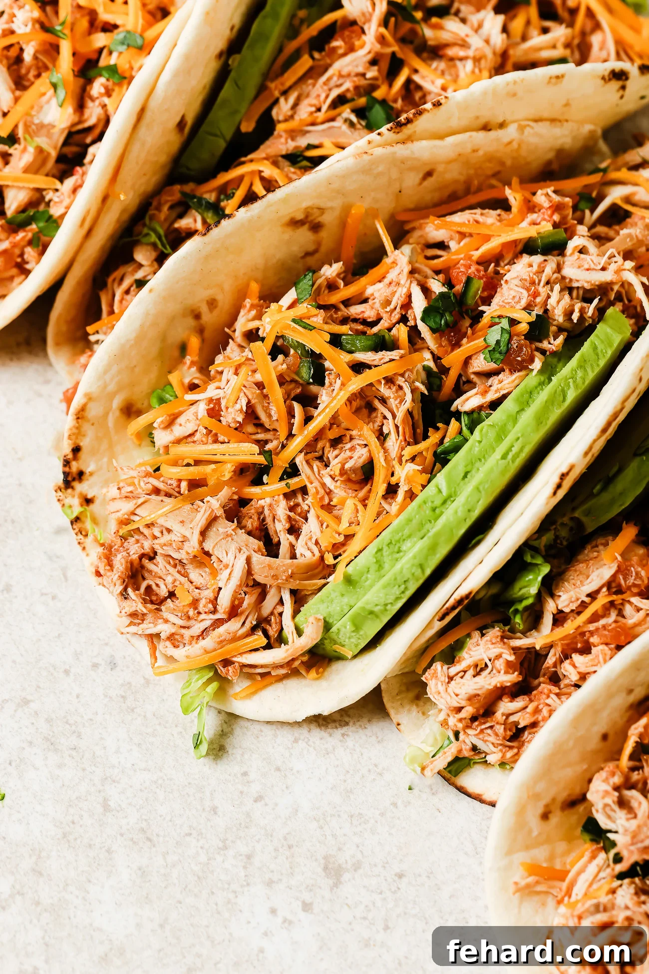 Slow Cooker Shredded Chicken Tacos with Flavorful Salsa 10 Close-up view of slow cooker chicken tacos filled with shredded chicken, salsa, and fresh toppings.