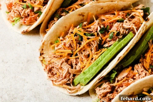 Slow Cooker Shredded Chicken Tacos with Flavorful Salsa 15 Close-up view of slow cooker chicken tacos filled with shredded chicken, salsa, and fresh toppings.