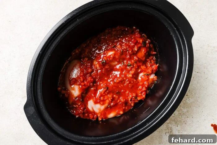 Slow Cooker Shredded Chicken Tacos with Flavorful Salsa 6 Chicken breasts with salsa inside a slow cooker.