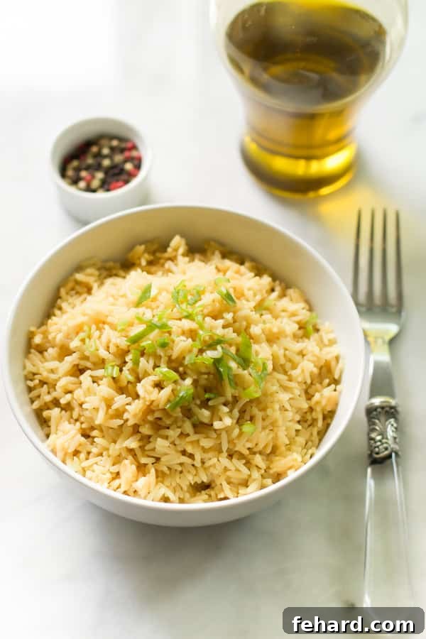 A fork lifts a perfect portion of fluffy white rice from a white bowl.
