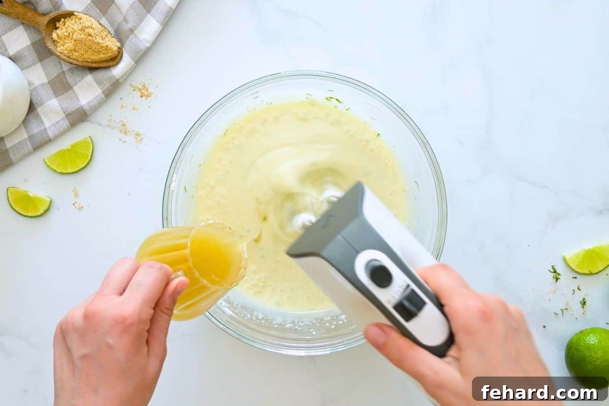 Key Lime Pie Recipe with Fresh Whipped Cream Handheld mixer mixing key lime pie filling while key lime juice is being slowly drizzled into mixing bowl.