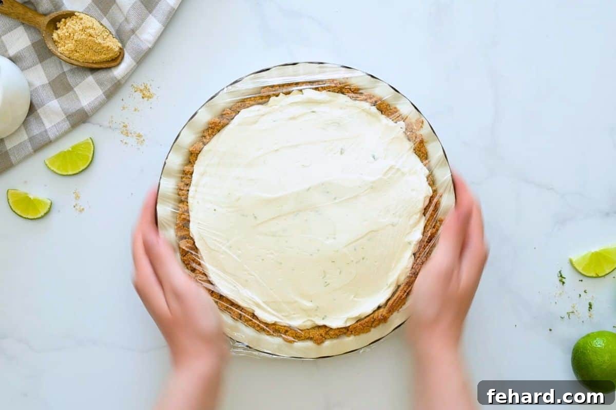 Easy Key Lime Pie with Homemade Graham Cracker Crust Key Lime pie assembled in homemade crust covered with plastic wrap before chilling.