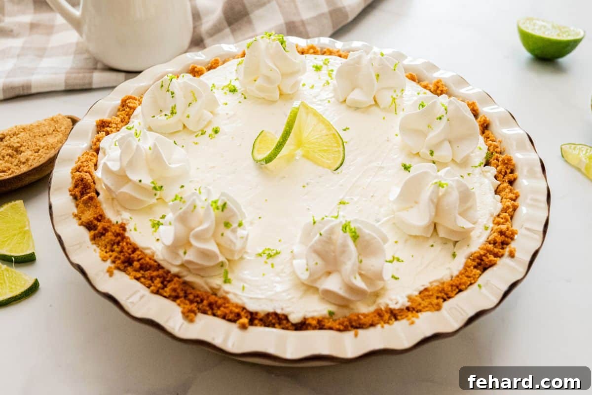 Easy Key Lime Pie Recipe Frozen Homemade key lime pie topped with fresh whipped cream, fresh lime slices, lime zest in homemade graham cracker crust.