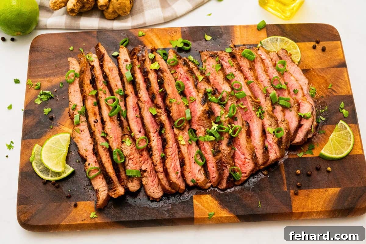 Marinated grilled flank steak sliced against the grain topped with cilantro, green onions, lime slices.