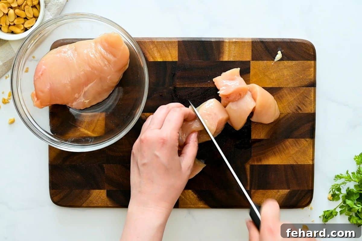 Chicken Kabobs Recipe Cutting chicken breasts into 2-inch cubes for chicken kabobs.